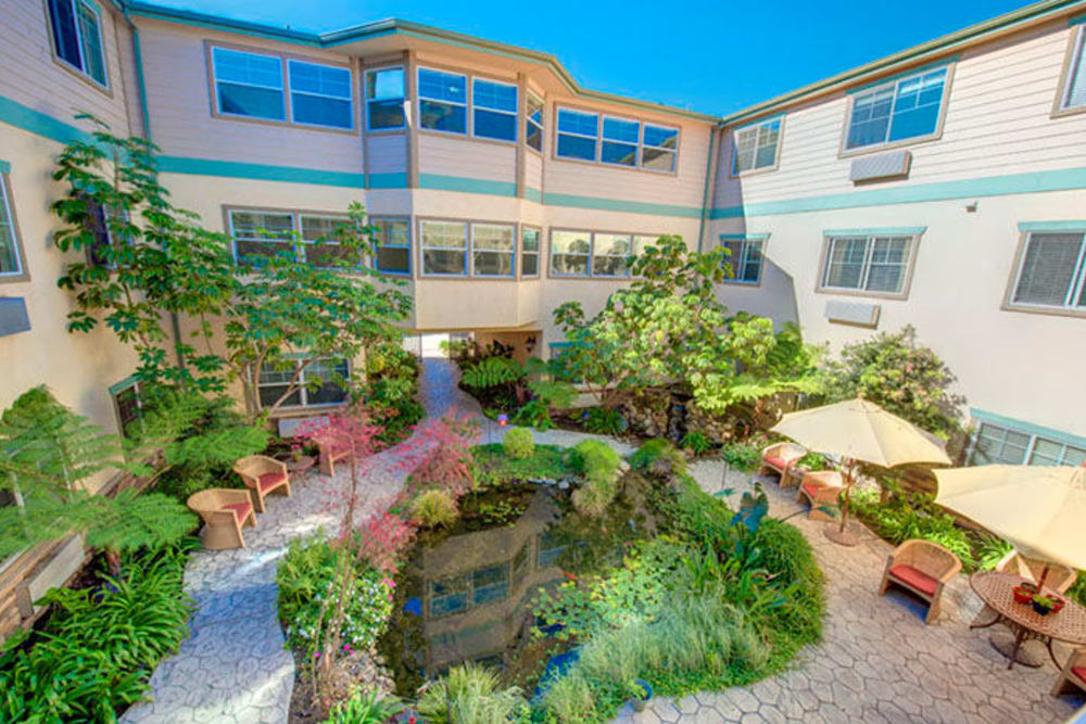 community courtyard with a fountain, garden, and circular path at Cypress Place in Ventura, California
