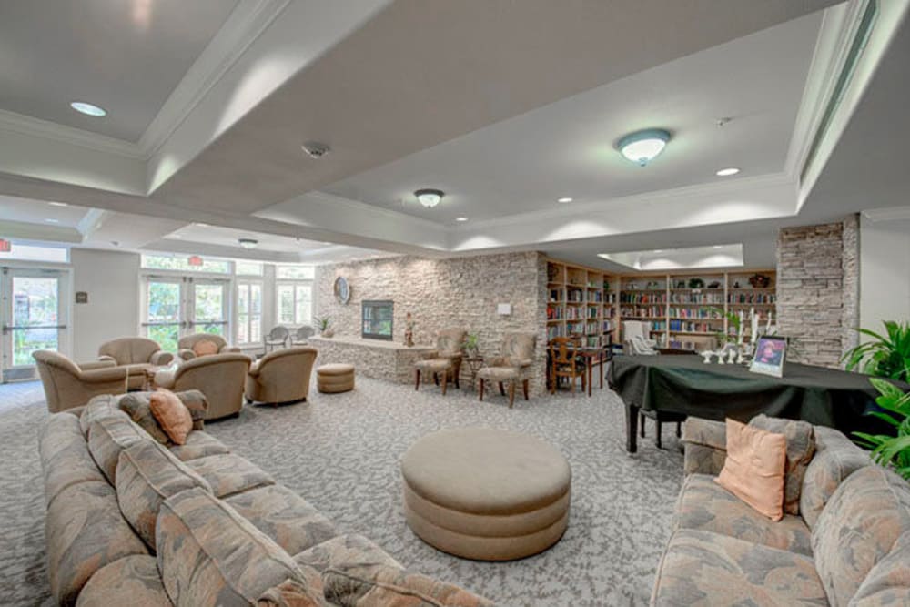 Community lounge with several long couches and access to a library at Cypress Place in Ventura, California