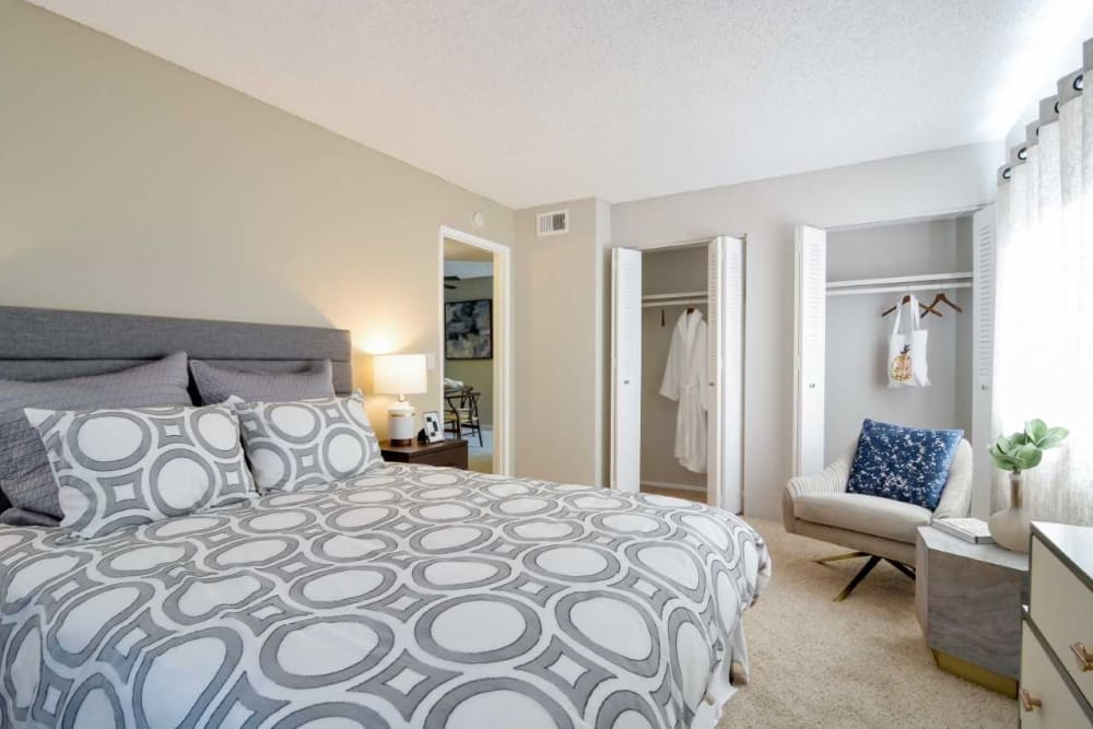 Ample closet space and plush carpeting in a model home's master bedroom at Waterstone Fremont in Fremont, California