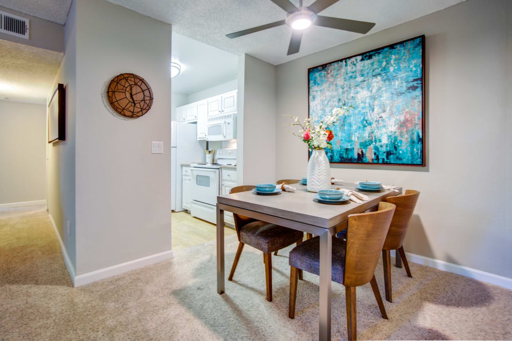 Dining area with a ceiling fan next to the kitchen in a model home at Waterstone Fremont in Fremont, California