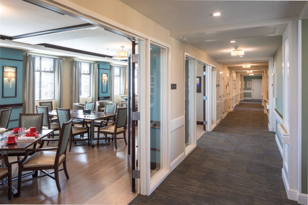Hallway passing by a bright dining room at Regency Palms Long Beach in Long Beach, California