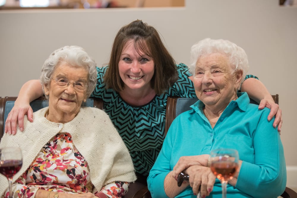 Two residents pose for a picture with a staff member from Inspired Living Hidden Lakes in Bradenton, Florida.