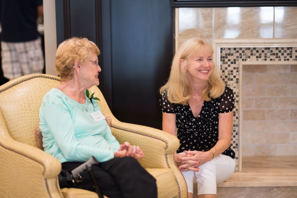 A resident chatting with a staff member at Inspired Living Kenner in Kenner, Louisiana. 