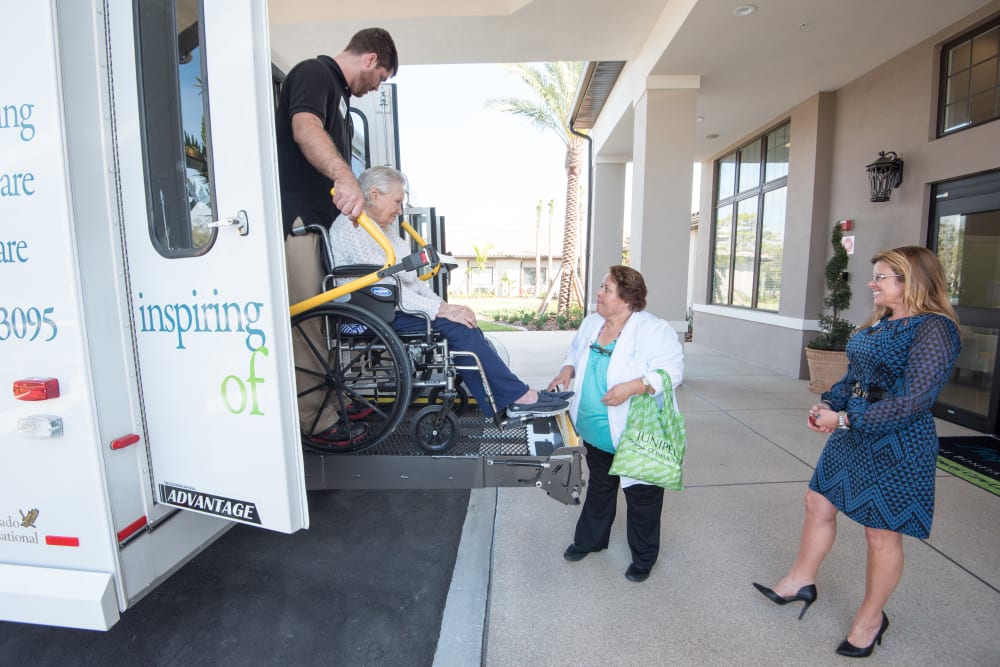 Staff helping a resident off a bus at Inspired Living Kenner in Kenner, Louisiana. 