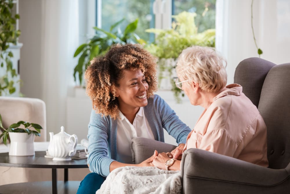 staff member comforting a resident at Inspired Living Kenner in Kenner, Louisiana. 