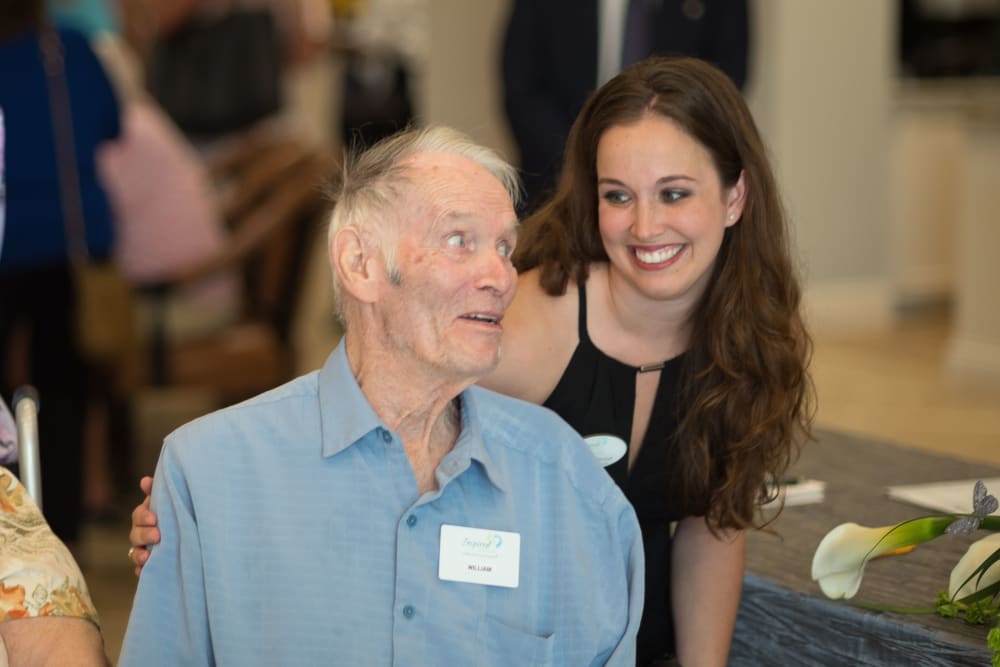 Staff member saying hello to a resident at an event at Inspired Living Kenner in Kenner, Louisiana. 