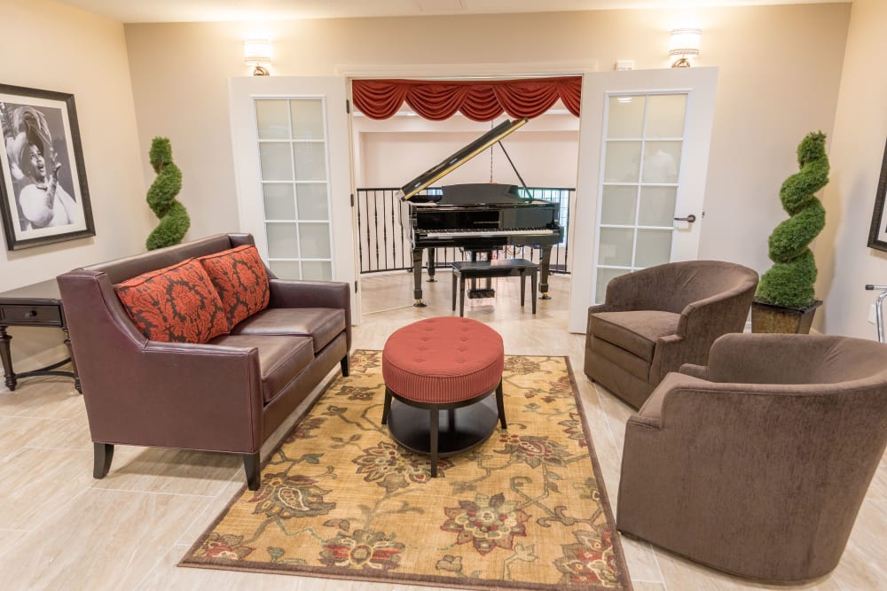 Lounge area with a piano at Inspired Living in Royal Palm Beach, Florida.