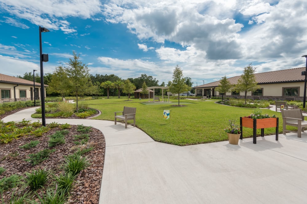 Courtyard with flowers and benches at Inspired Living in Royal Palm Beach, Florida.