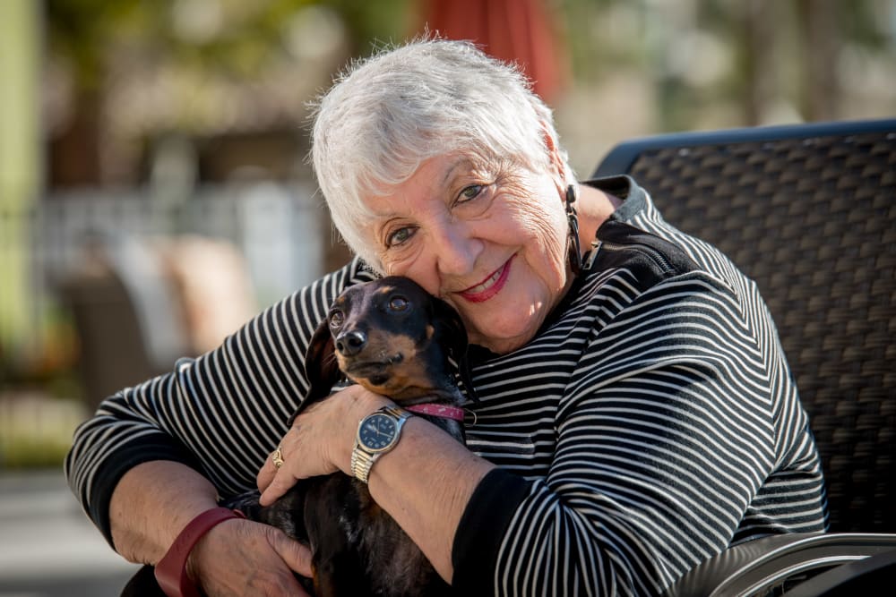 A resident hugging her dog at Inspired Living Royal Palm Beach in Royal Palm Beach, Florida. 
