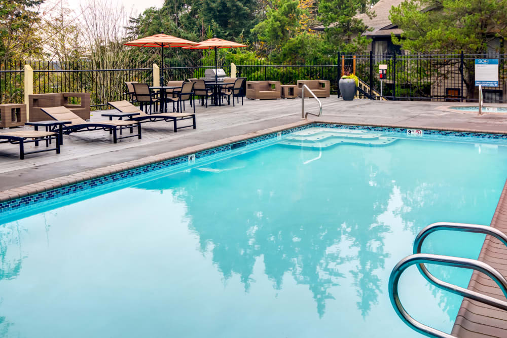 Serene swimming pool with chaise lounge chairs nearby at Sofi at Somerset in Bellevue, Washington