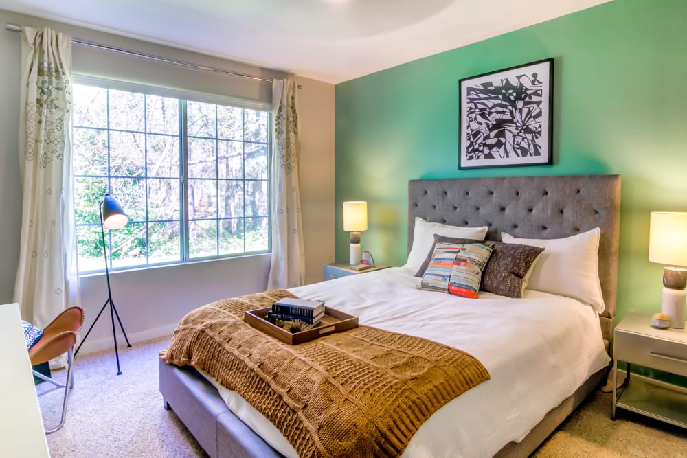 Large bay windows and an accent wall in a model home's master bedroom at Sofi at Murrayhill in Beaverton, Oregon