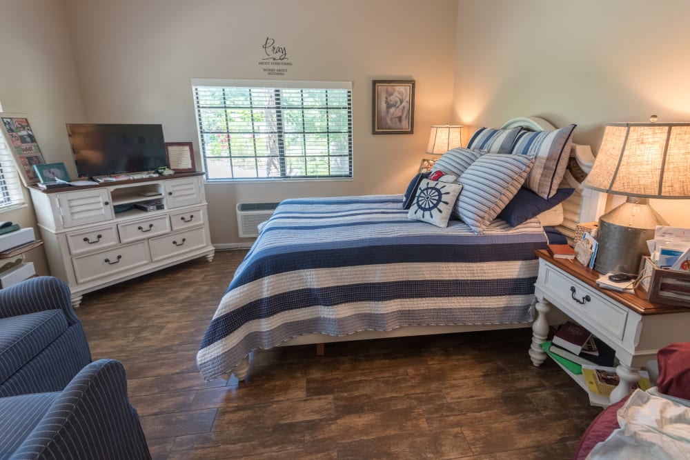 A spacious memory care bedroom with a TV at Inspired Living Sarasota in Sarasota, Florida. 