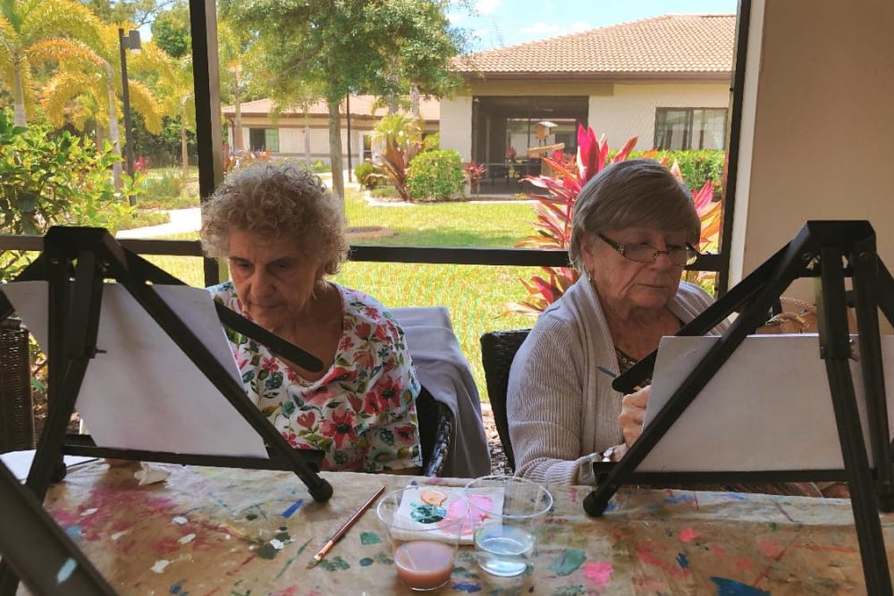 Two residents painting at Inspired Living Tampa in Tampa, Florida. 