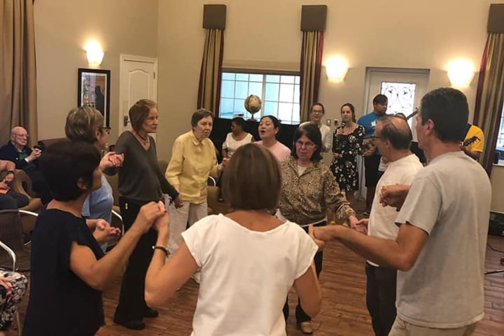 Residents in a circle playing a game at Inspired Living Tampa in Tampa, Florida