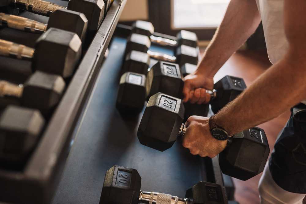 Resident selecting dumbbells in the fitness center at Springfield Apartments in Murfreesboro, Tennessee