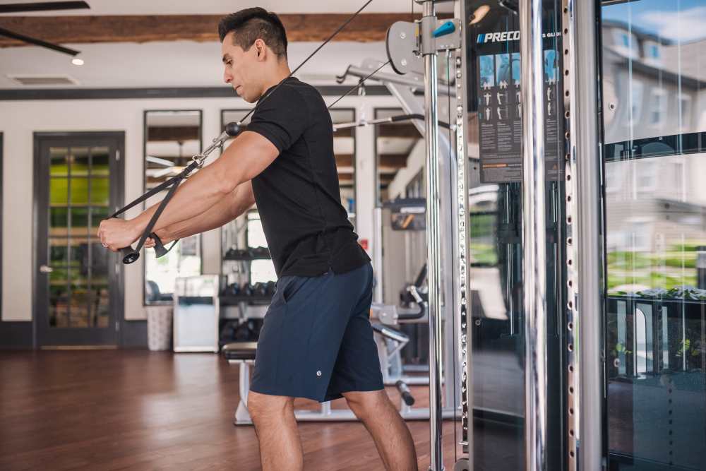 Resident using the cable machine in the fitness center at Springfield Apartments in Murfreesboro, Tennessee