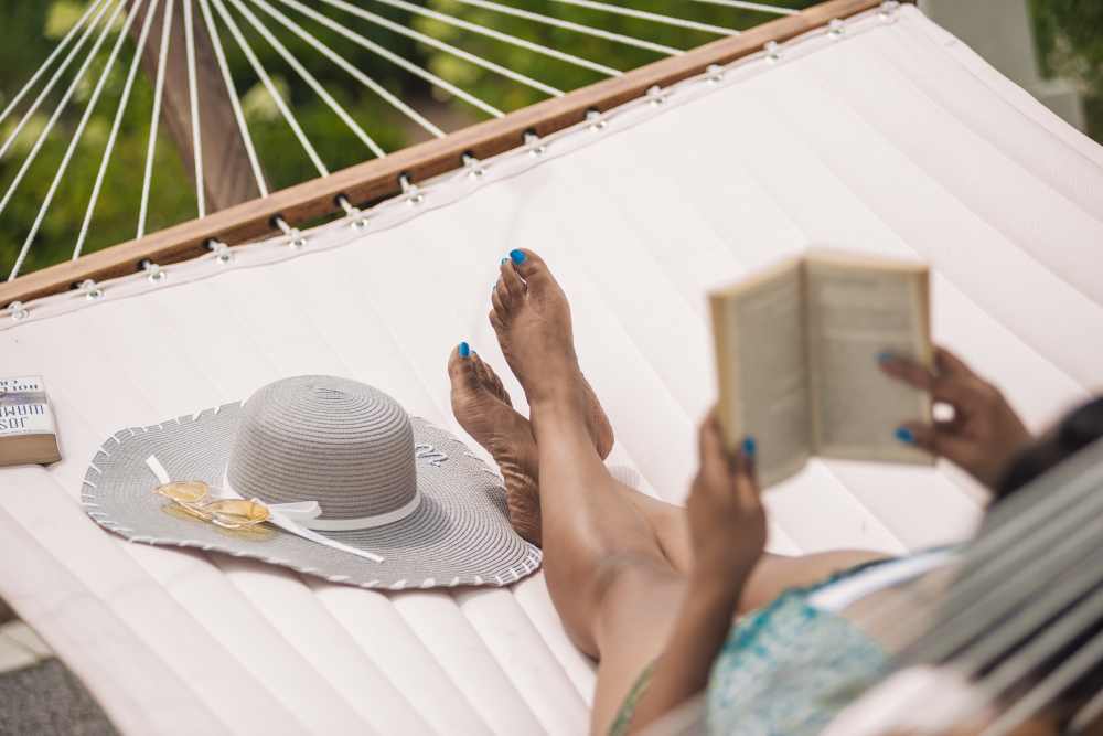 Resident relaxing in a hammock with a book at Springfield Apartments in Murfreesboro, Tennessee