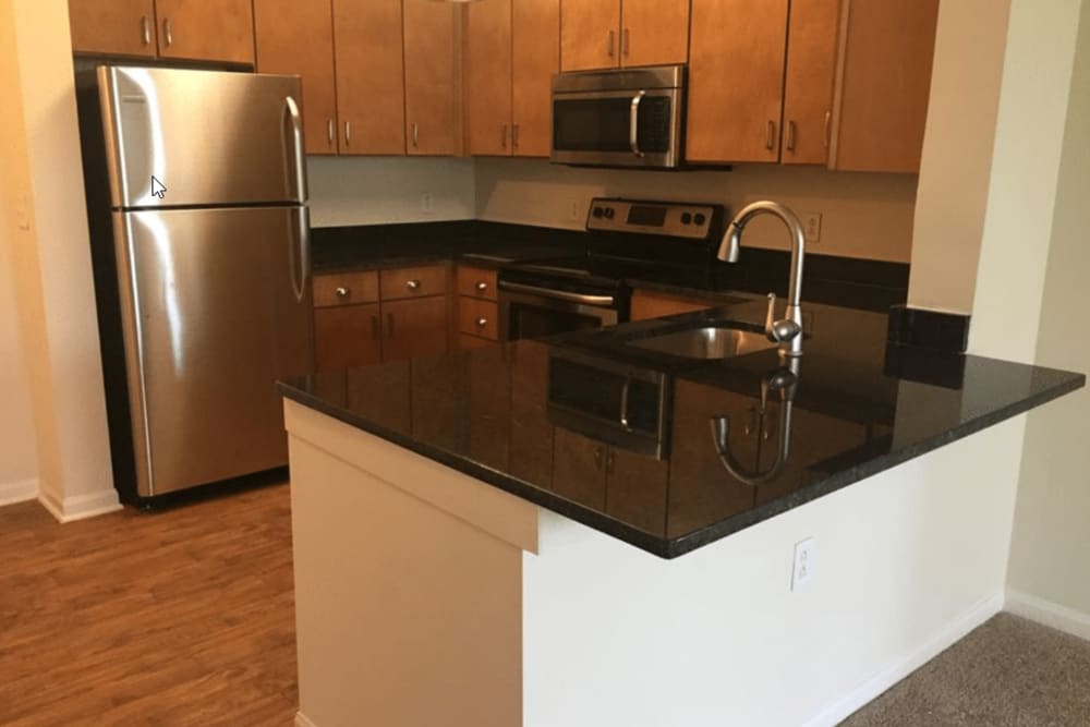 Modern kitchen appliances, cabinetry and hardwood flooring at Westville Village Apartments in New Haven, Connecticut