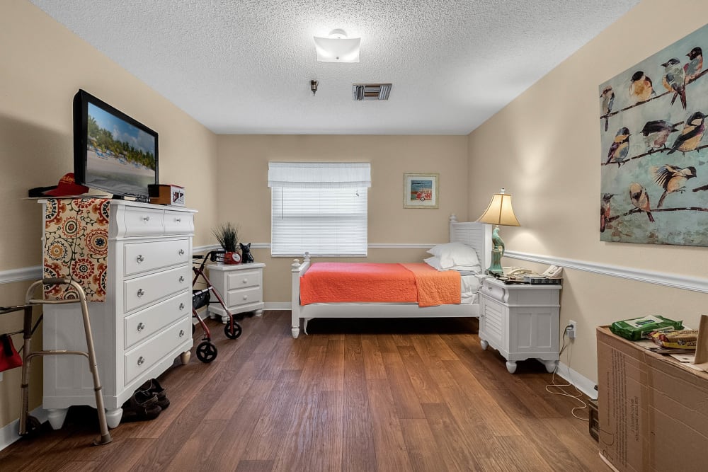 Model bedroom with twin bed and dresser at Forest Oaks of Spring Hill