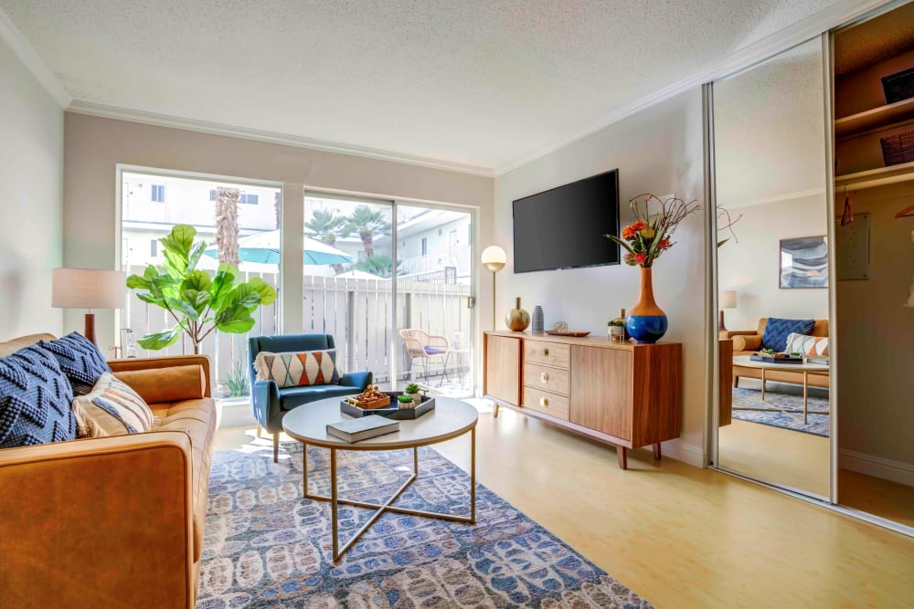 Cozy living area with a wall-mounted flatscreen TV in a model home at Sofi Redwood Park in Redwood City, California