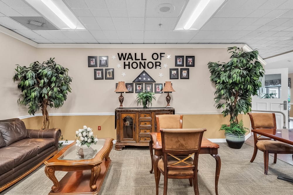 Community are with chairs and couch highlighting wall of fame at Spring Oaks