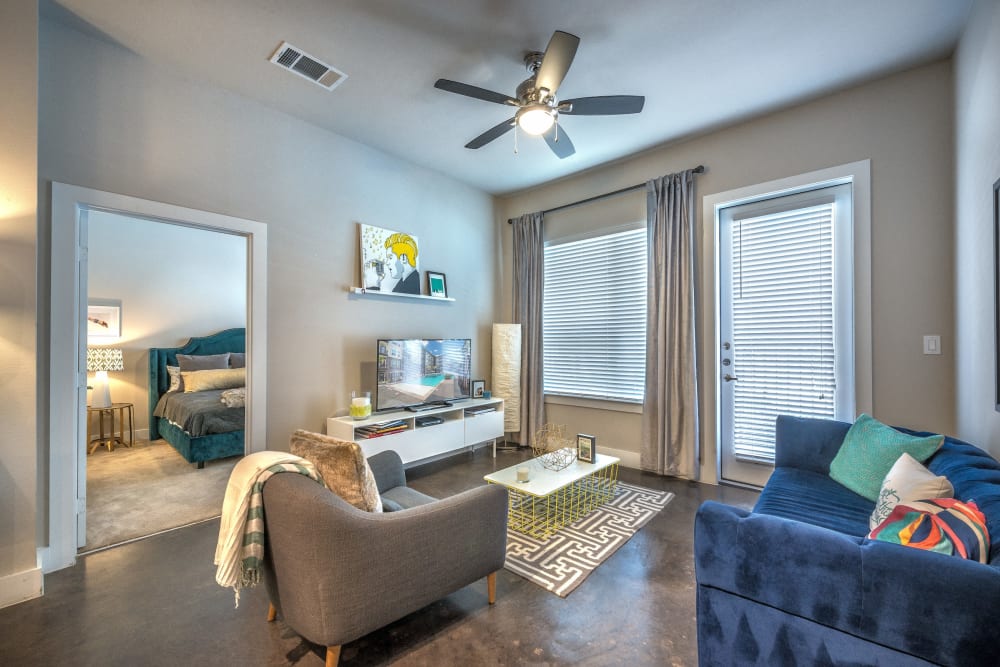 Modern decor and a ceiling fan in a model home's living area at Olympus at Ross in Dallas, Texas