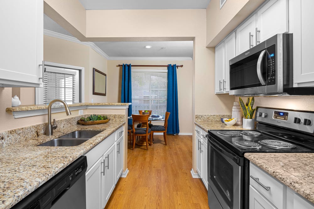 Kitchen with stainless steel appliances and view of dining room at The Lodge at Shavano Park