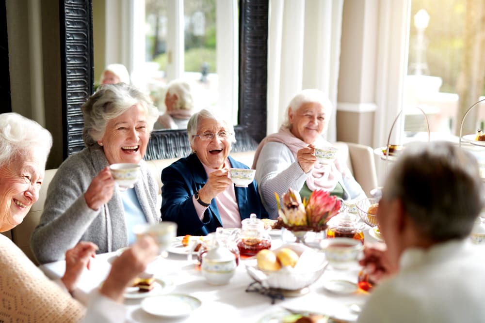 A group of residents having tea together at The Arbours at Linden Pointe in Winnipeg, Manitoba