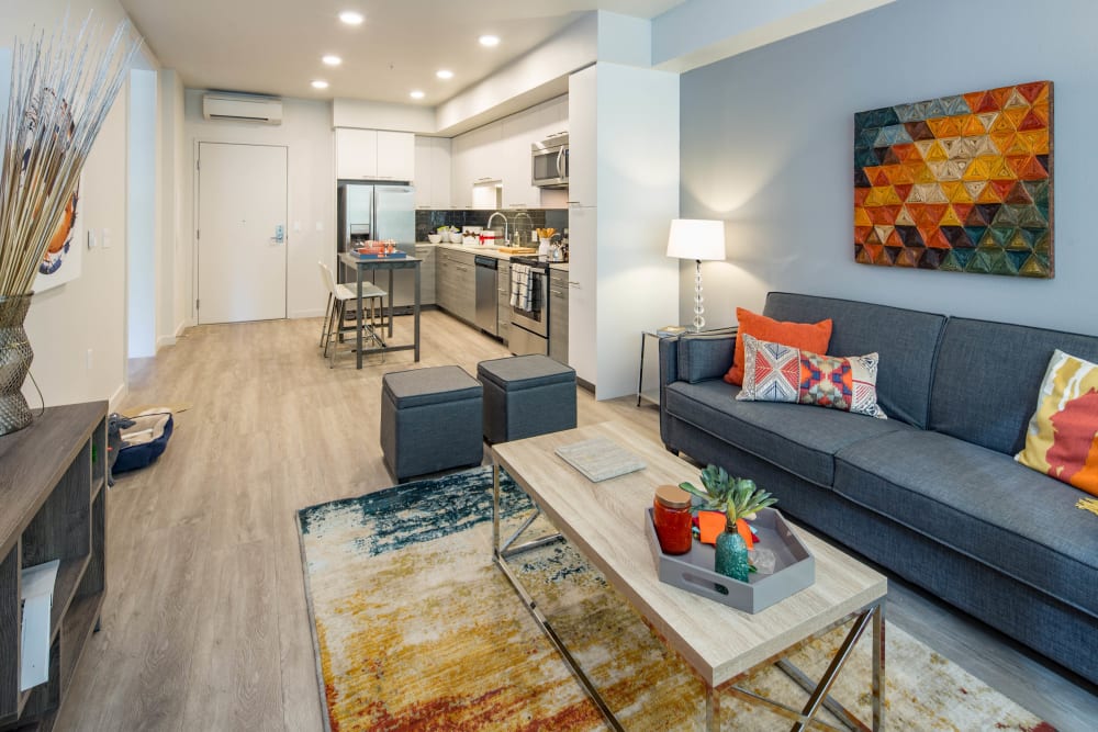 Spacious open-concept living area with an accent wall in a model home at EVIVA Midtown in Sacramento, California