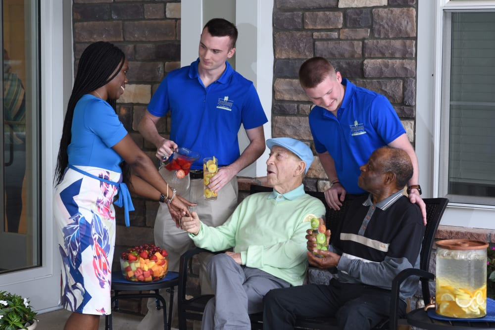 Seniors and caregivers enjoying a drink of water together