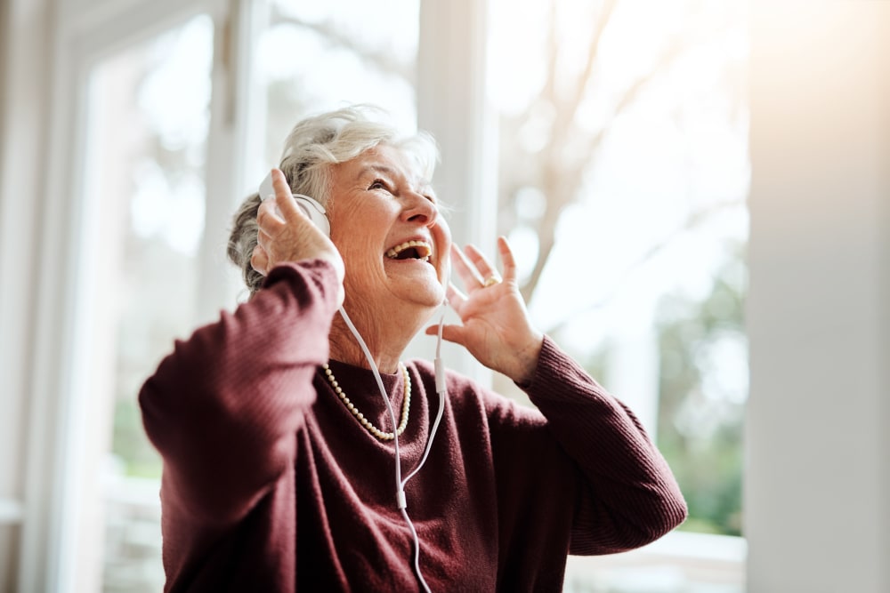 Resident enjoying music over headphones in an apartment at The Preserve of Roseville in Roseville, Minnesota.