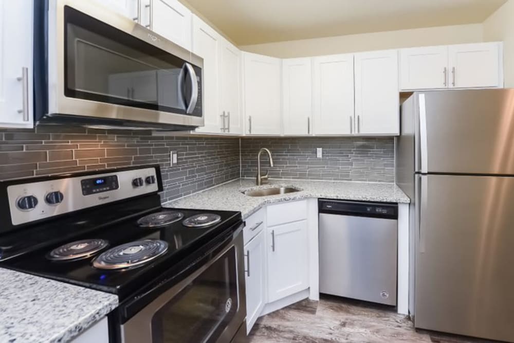 Contemporary kitchen with white cabinets and stainless-steel appliances at The Fairways Apartment Homes in Blackwood, New Jersey