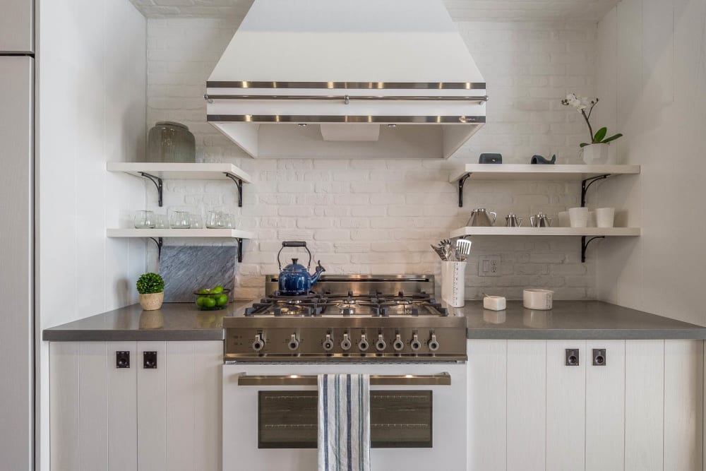 Gourmet kitchen with granite countertops and bright white cabinetry in a model home at Cadia Crossing in Gilbert, Arizona