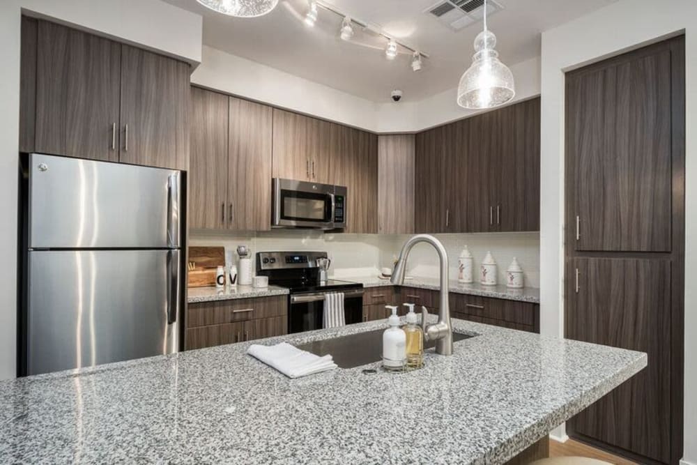 Kitchen island with a granite countertop in a model home's kitchen at Cadia Crossing in Gilbert, Arizona