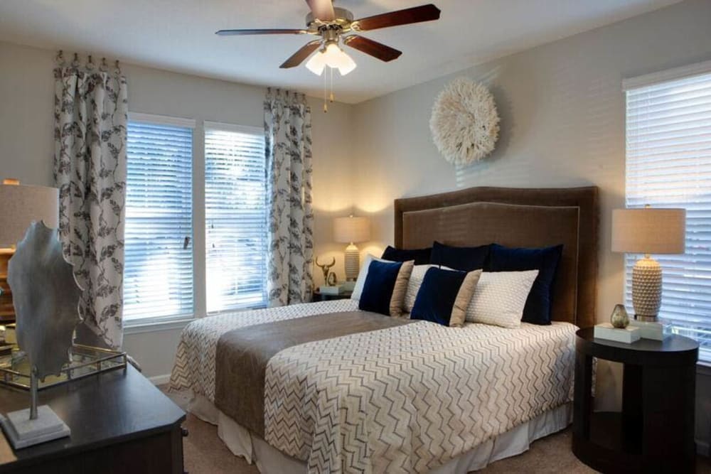 Ceiling fan and modern furnishings in a model home's primary bedroom at Canopy at Citrus Park in Tampa, Florida