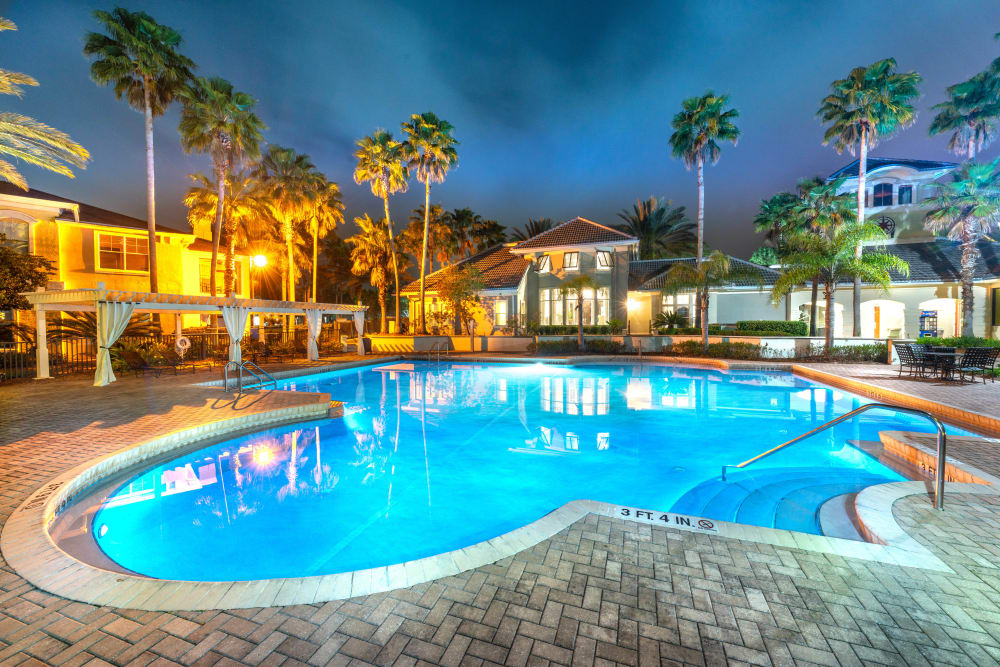 Swimming pool lit up with underwater lighting in the evening at Cape House in Jacksonville, Florida