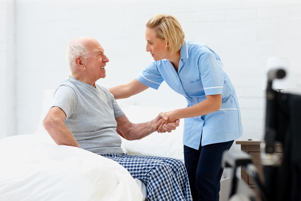 Staff assists resident out of bed at The Atrium in Rockford, Illinois.