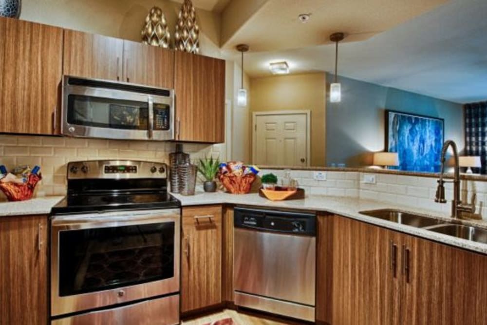 Gourmet kitchen with granite countertops and custom wood cabinetry in a model apartment at Elevation Chandler in Chandler, Arizona