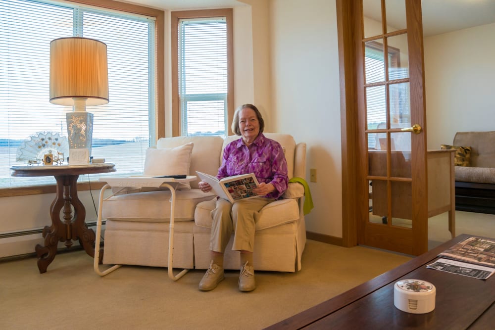 Resident reads a book in her apartment at Meadow Lakes Senior Living in Rochester, Minnesota.