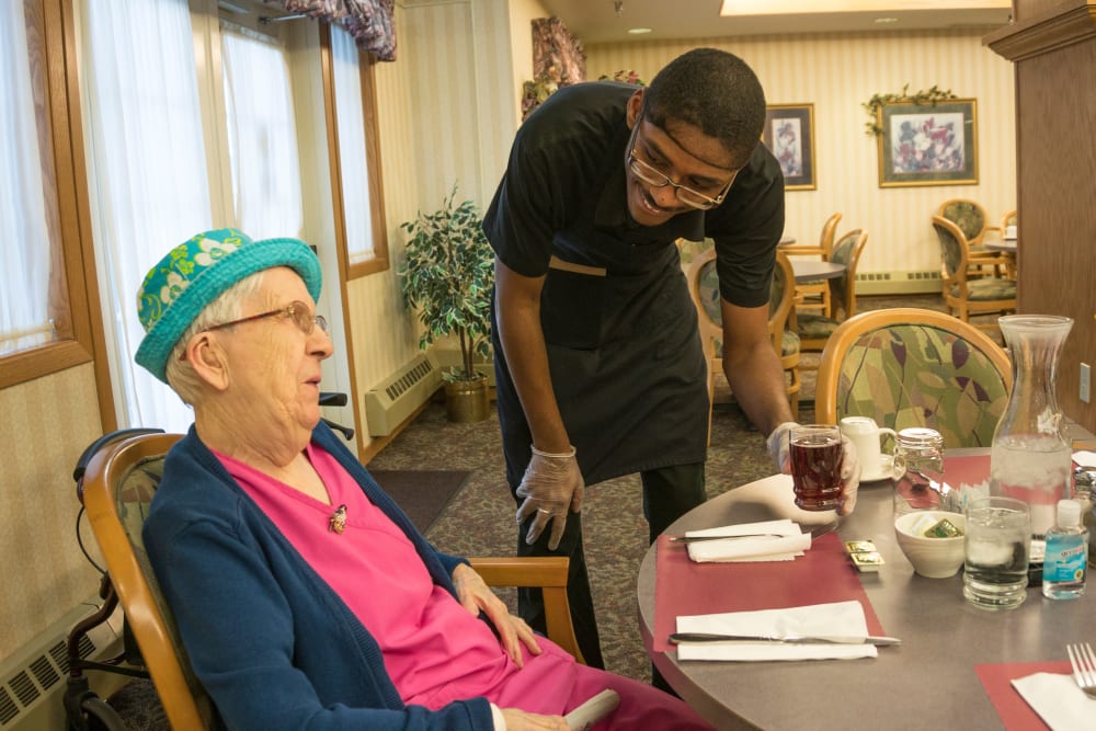 Resident chats with staff in dining room at Meadow Lakes Senior Living in Rochester, Minnesota