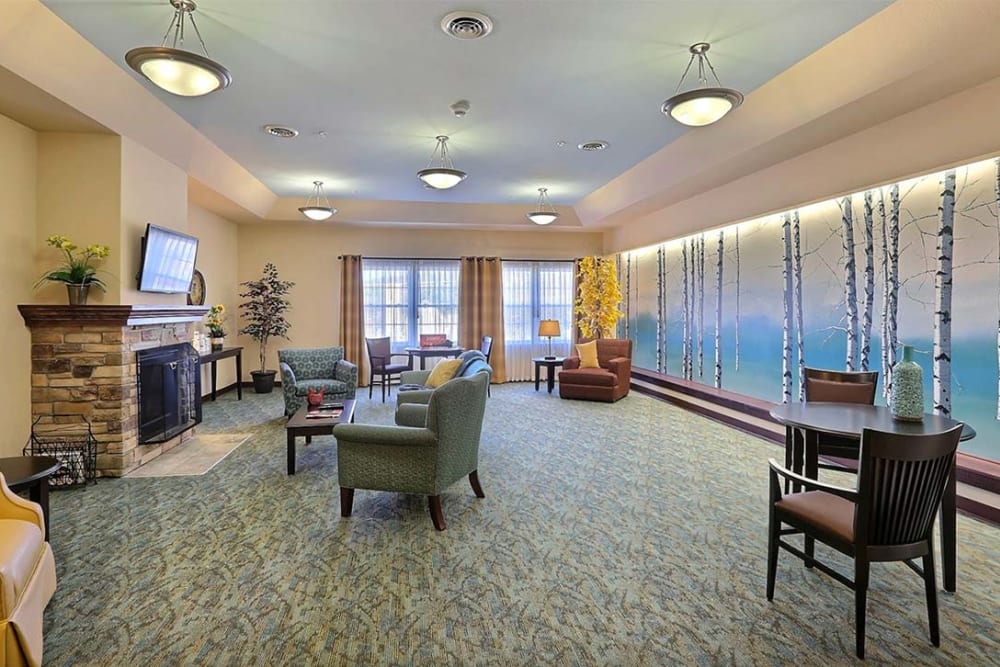 Brightly lit resident lounge with fireplace at Milestone Senior Living Cross Plains in Cross Plains, Wisconsin.