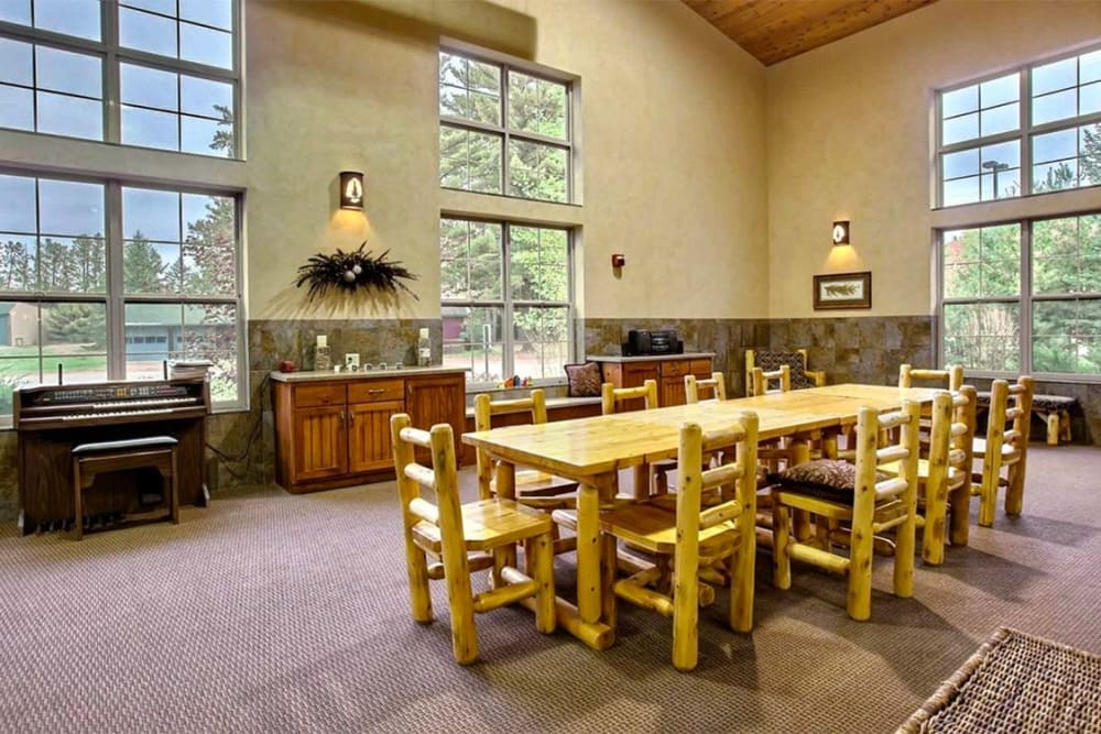 Activity room with big windows and a piano at Milestone Senior Living Eagle River in Eagle River, Wisconsin.