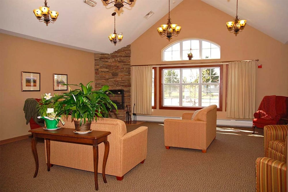 Resident lounge with picture windows and fireplace at Milestone Senior Living Eau Claire in Eau Claire, Wisconsin.