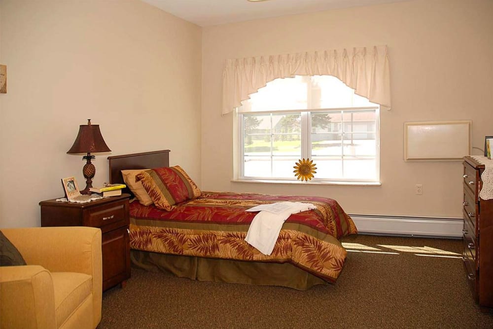 Resident bedroom with a side table at Milestone Senior Living Eau Claire in Eau Claire, Wisconsin.