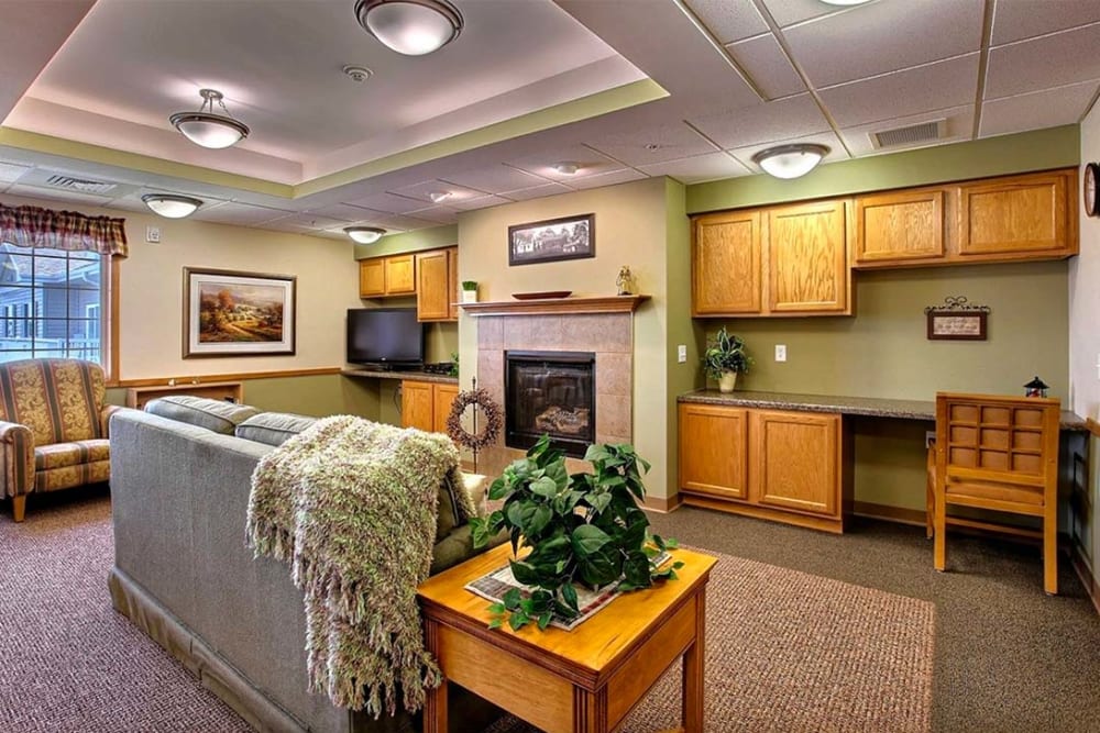 Resident lounge with writing desk and fireplace at Milestone Senior Living Hillsboro in Hillsboro, Wisconsin.