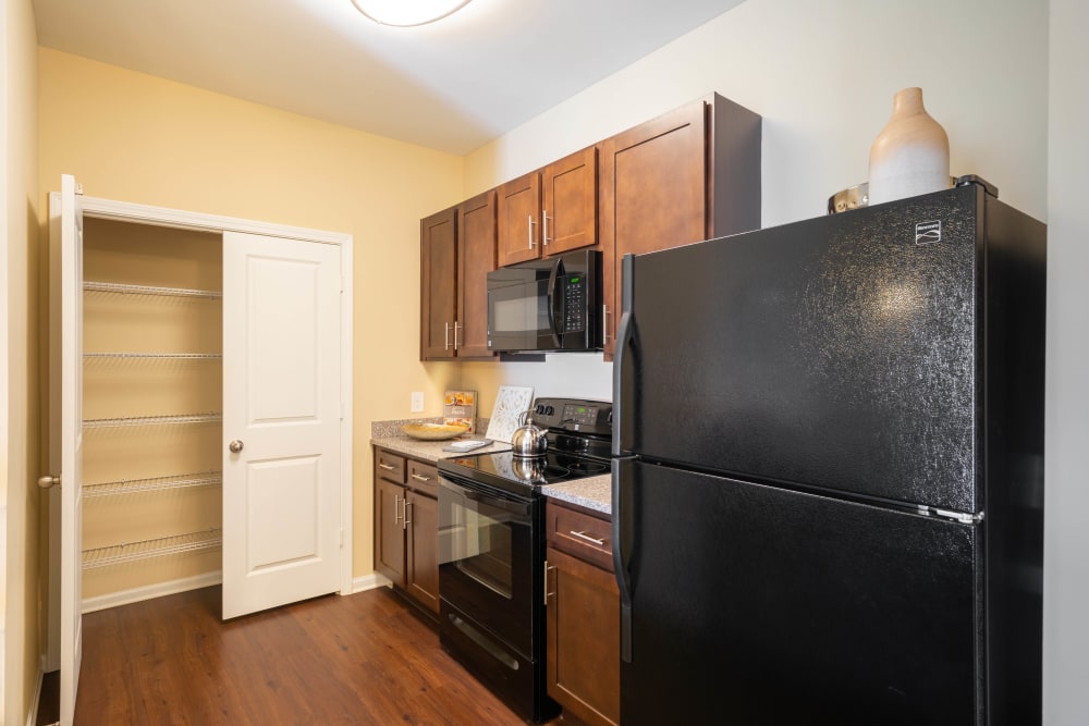 Hardwood flooring and custom wood cabinetry in a model home's kitchen at Legends at White Oak in Ooltewah, Tennessee