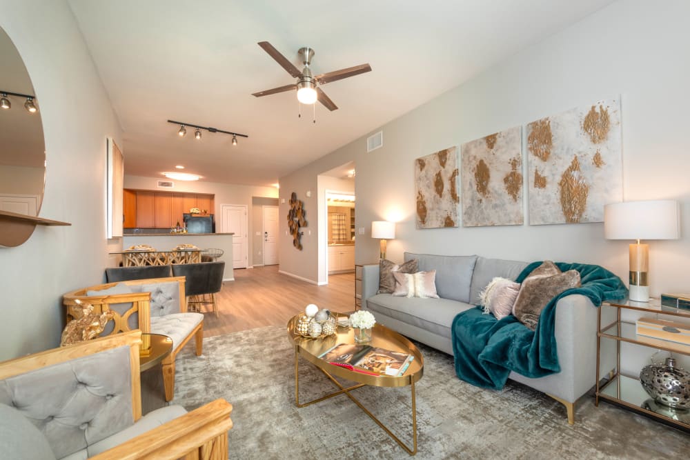 Large open-concept living area with a ceiling fan in a model apartment home at Olympus at Daybreak in South Jordan, Utah