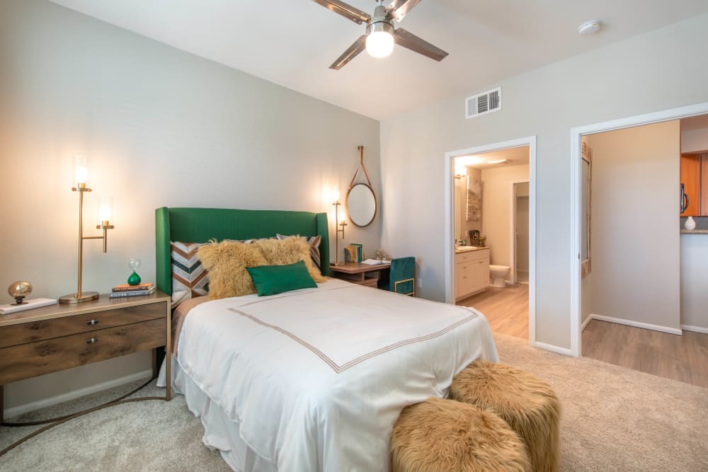 Ceiling fan and an en suite bathroom in a model home's primary bedroom at Olympus at Daybreak in South Jordan, Utah