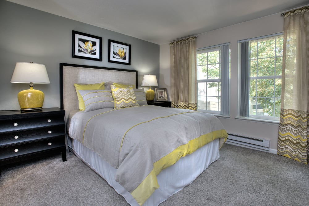Master bedroom with large windows for natural lighting at Slate Ridge at Fisher's Landing Apartment Homes in Vancouver, Washington