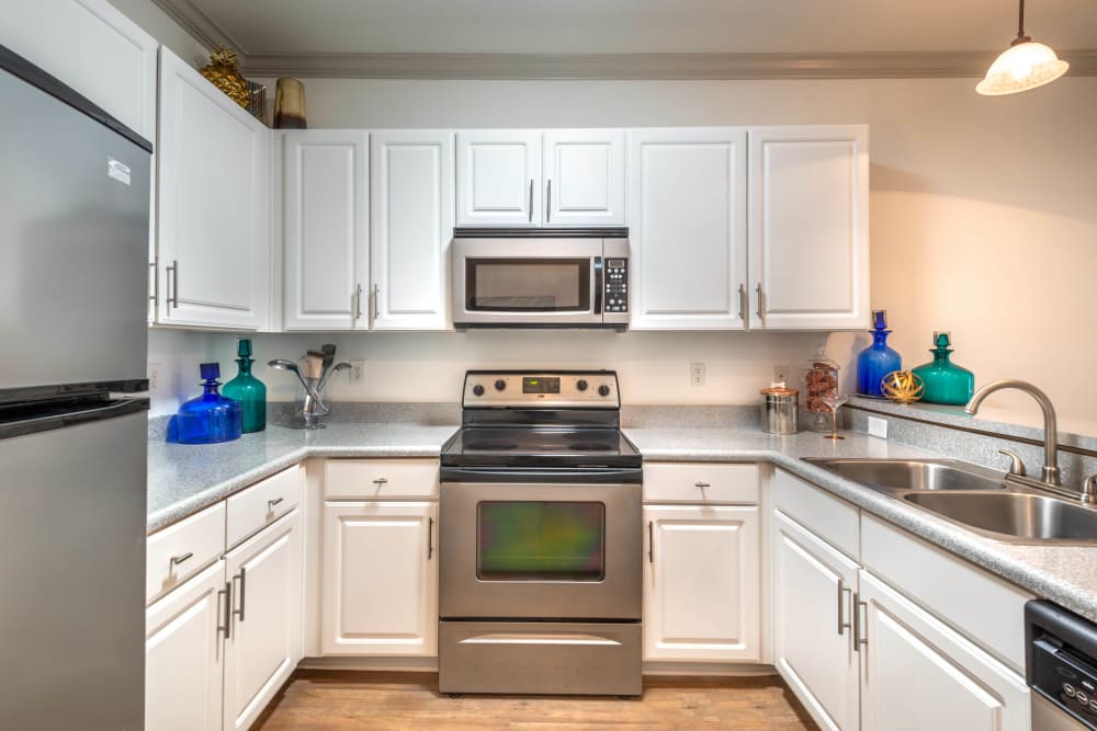 Stainless-steel appliances and white cupboards in a model home's kitchen at Olympus Carrington in Pooler, Georgia